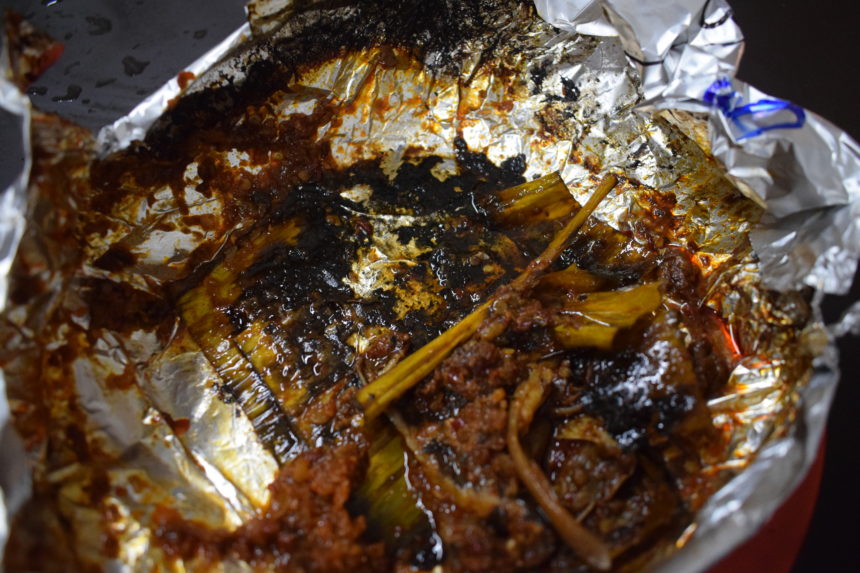 bottom of foil parcel showing blackened banana leaf