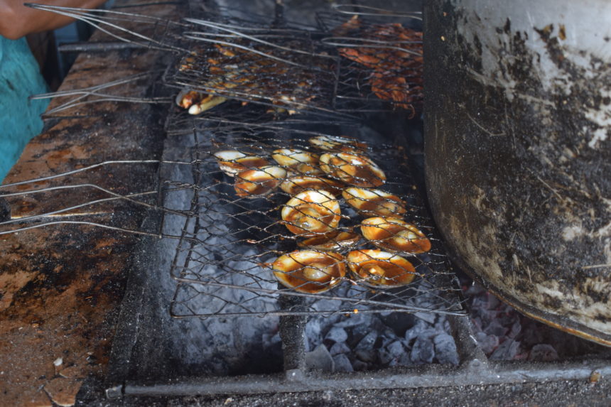 clams on grill covered with seafood sauce