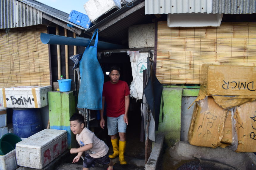 Man and child leaving hidden entrance to Jimbaran Fish Market