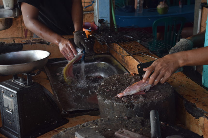 a warung gutting fish bought at the market 