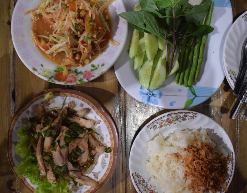 the spread of dishes we ordered at Ba Dow restaurant Kuraburi, including som tam, nam tok moo and sticky rice