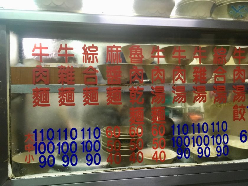 Fuhong Beef Noodles Menu printed on glass front of food serving station