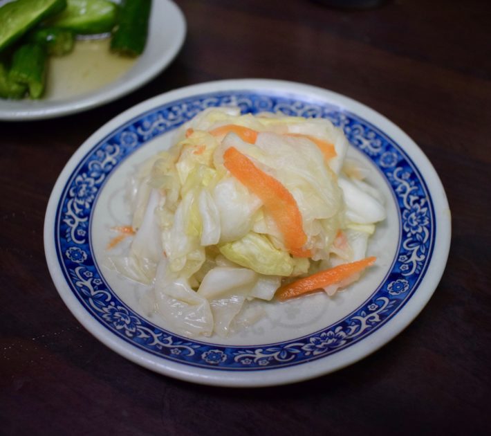 Small plate of Taiwanese golden kimchi showing off-white cabbage and bright orange strips of carrot