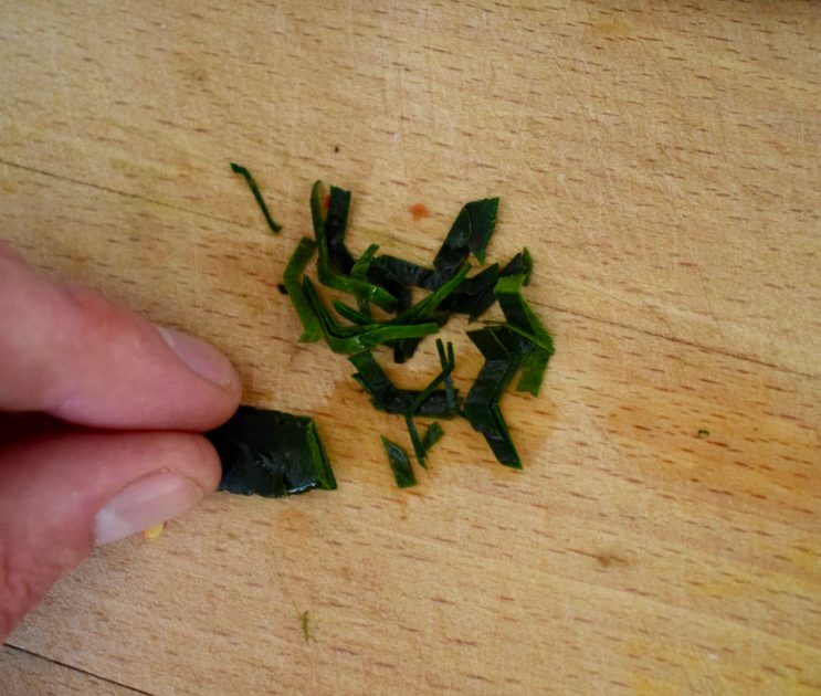 Cutting a kaffir lime lime leaf into small strips