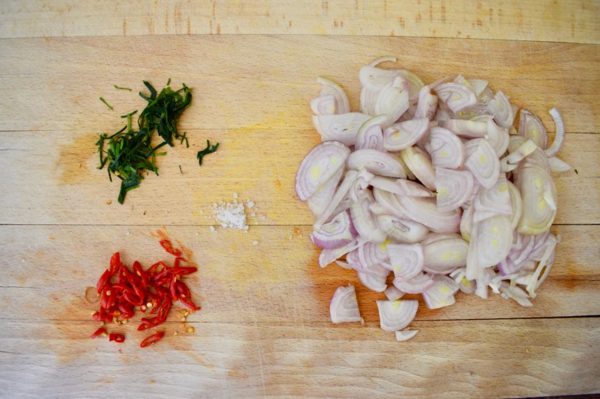 Chopped shallots chillies kaffir lime leaves and salt ready for making sambal matah