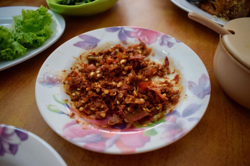 An unusual sambal terasi made with dried chillies in a small red dish at a warung in solo, Java