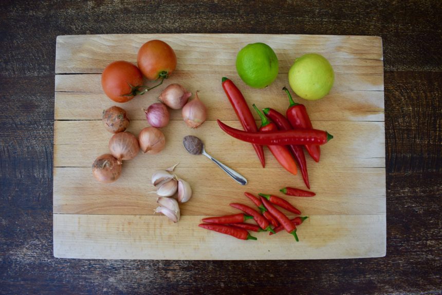 The ingredients needed to make sambal terasi on a chopping board