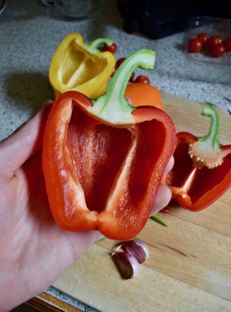 A bell pepper/capsicum cut lengthways with pith and seeds removed showing how to cut the bell peppers for this italian roasted peppers recipe